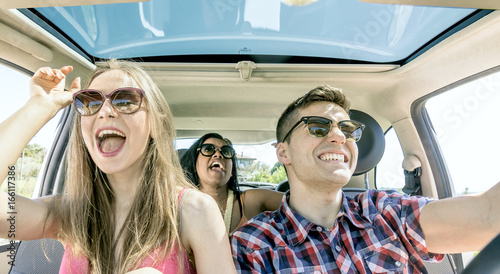 young friends fun inside car laughing happy  singing in group and driving. © pixelrain