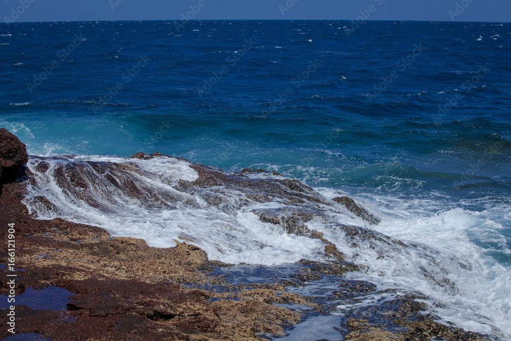 Stony ocean shore. Coast of the ocean on the islands. Canary Islands. Spray of the ocean