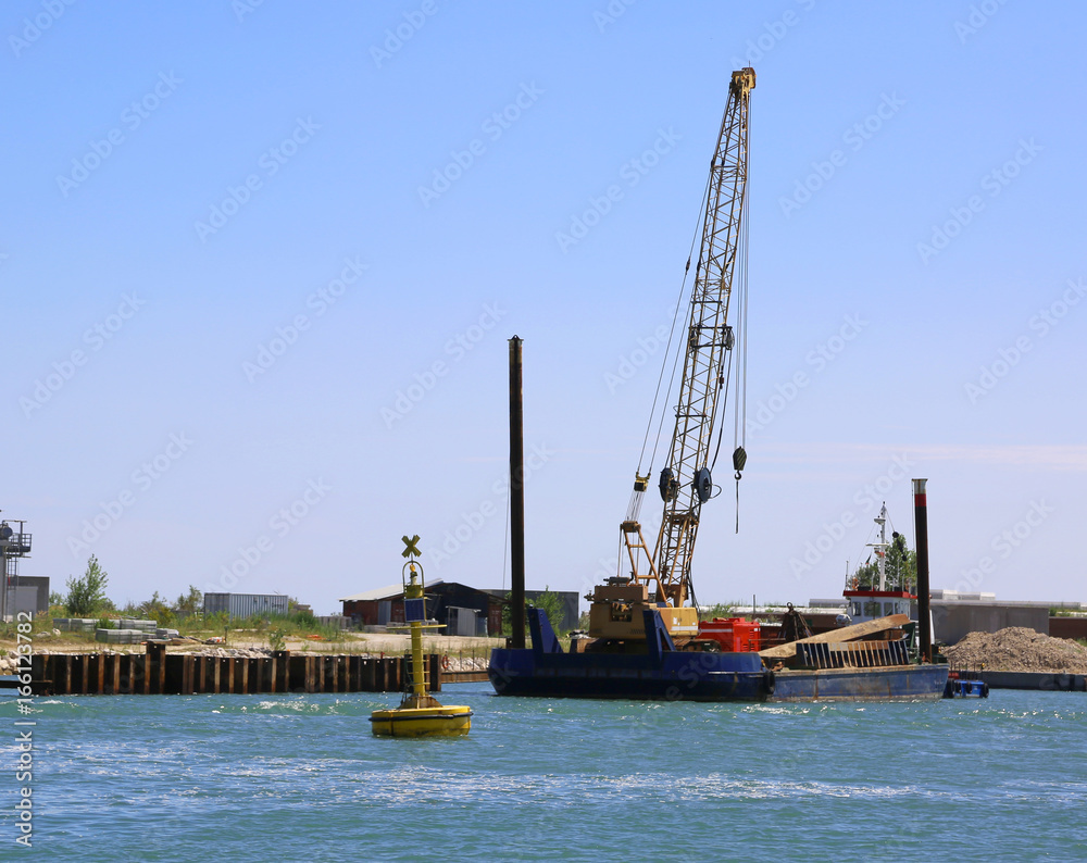 cranes at a shipyard for the construction of a dam on the sea cranes at a shipyard for the construction of a dam on the sea