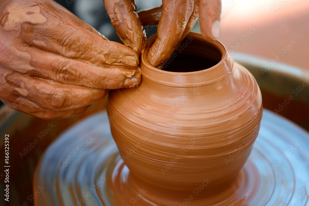 Potter making ceramic pot on the pottery wheel Potter making ceramic pot on the pottery wheel