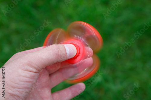 Closeup red fidget spinner in hand. Popular spinner gadget photo