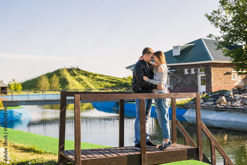 Happy and young pregnant couple hugging outdoors