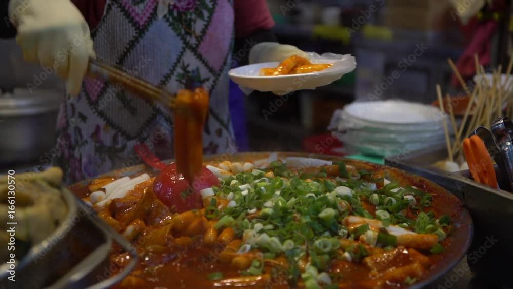 4K Popular Korean street food vendors with delicious Tteok-bokki. Stir-fried rice cakes made from long, white, cylinder-shaped called tteokmyeon or garae-tteok. Gukje International Market in Busan-Dan