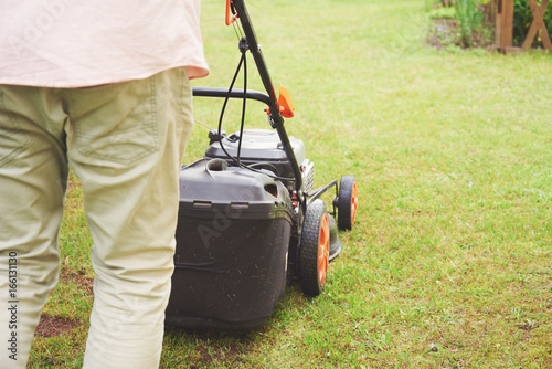 Obraz na płótnie Man handling lawn with lawnmower. w salonie