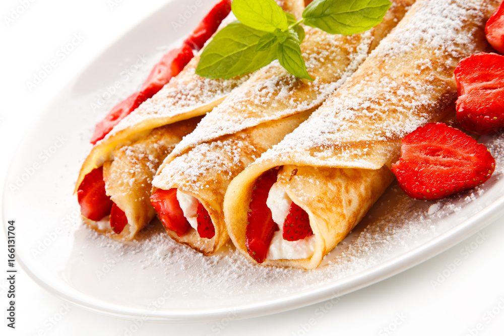 Crepes with strawberries and cream on white background Crepes with strawberries and cream on white background