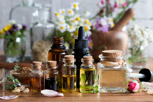 Selection of essential oils with various herbs and flowers