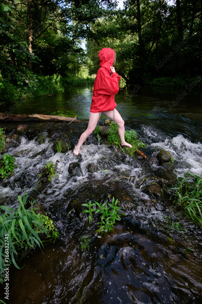 girl in red waterproof jacket fording mountain river girl in red waterproof jacket fording mountain river