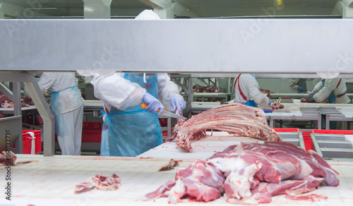 cutting meat slaughterhouse workers in a meat factory.