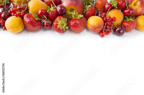 Various fresh summer berries. Top view. Ripe strawberries, redcurrants, apricots, nectarines and cherries on white background. Berries at border of image with copy space for text. Background berries.