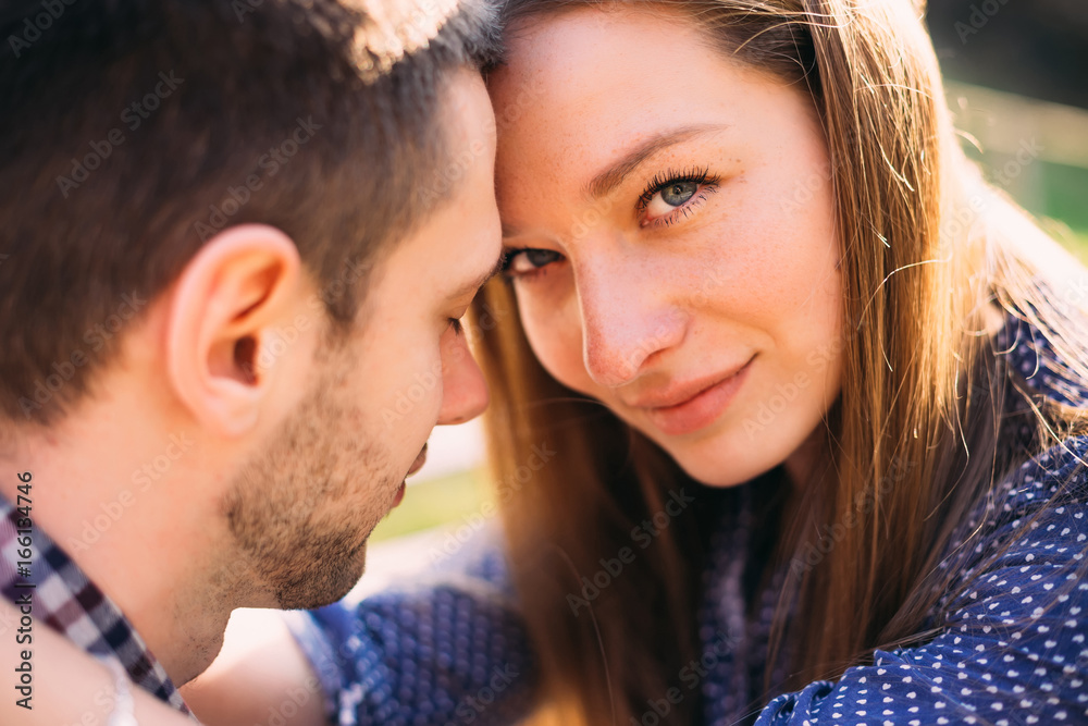 Closeup of two young people in love. Beautiful girl hugging her Closeup of two young people in love. Beautiful girl hugging her