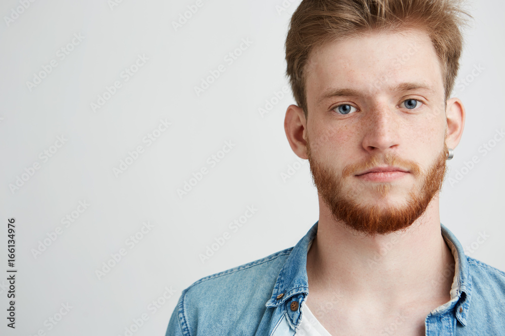 Portrait of young handsome man with beard looking at camera over white background. Portrait of young handsome man with beard looking at camera over white background.