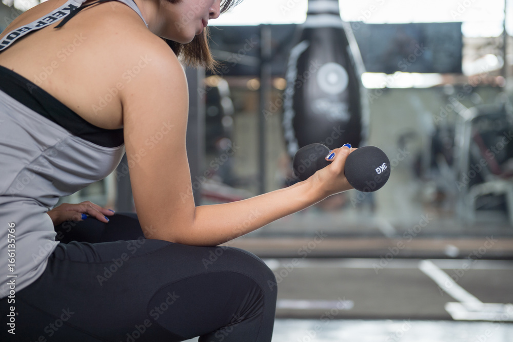 Fototapeta premium Young beautiful woman doing exercises in fitness gym