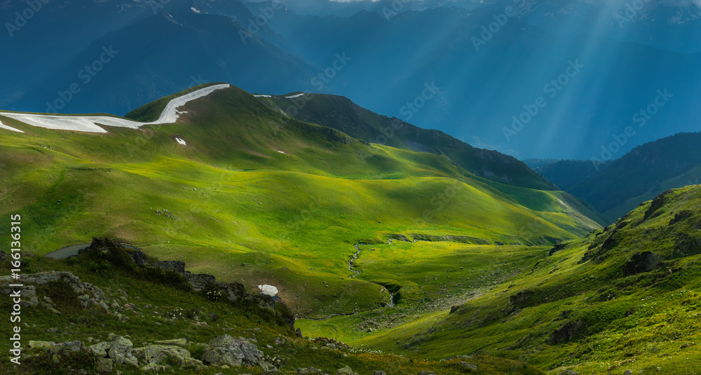 Green river valley in beams of evening sun. Caucasus mountains. - obrazy, fototapety, plakaty 