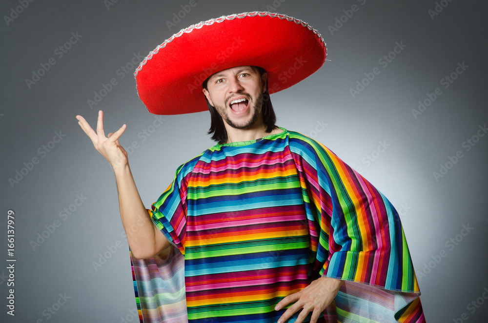 Man in a vivid mexican poncho gray background isolated Man in a vivid mexican poncho gray background isolated