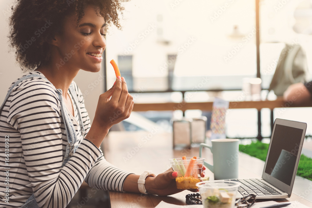 Pleasant charming girl is enjoying her lunch Pleasant charming girl is enjoying her lunch