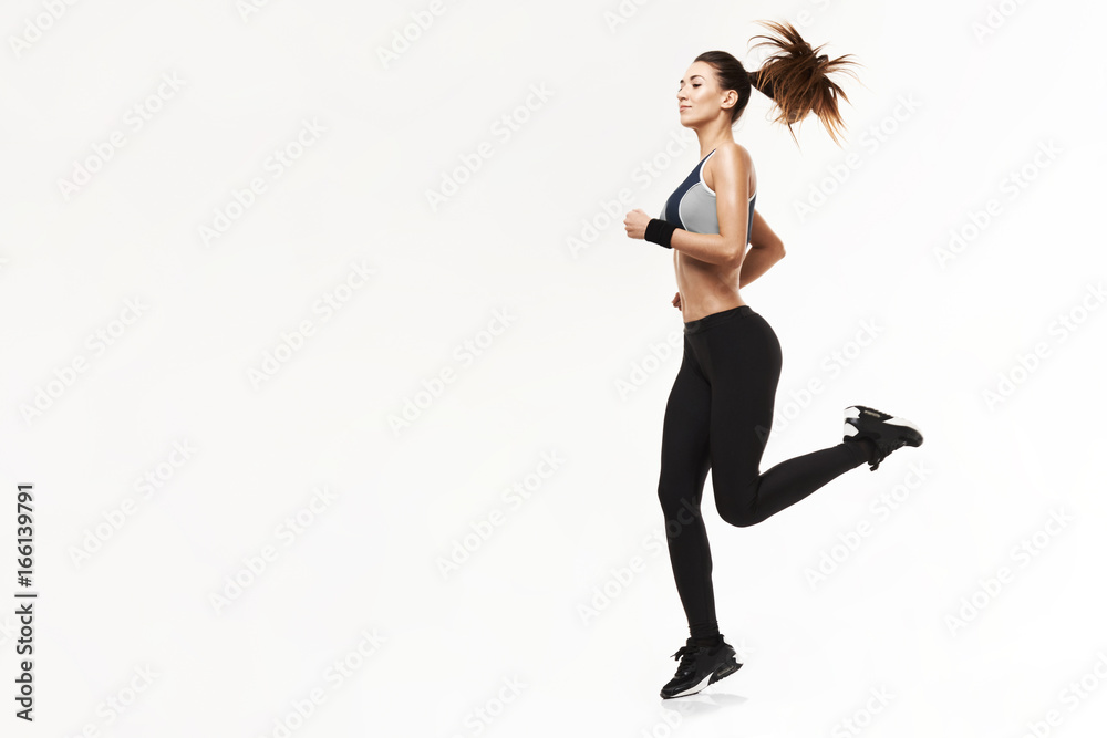 Beautiful athletic girl in sportswear training running over white background. Copy space. Beautiful athletic girl in sportswear training running over white background. Copy space.