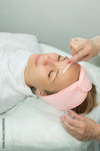 Beautiful young girl on facial cleansing procedure at a cosmetologist