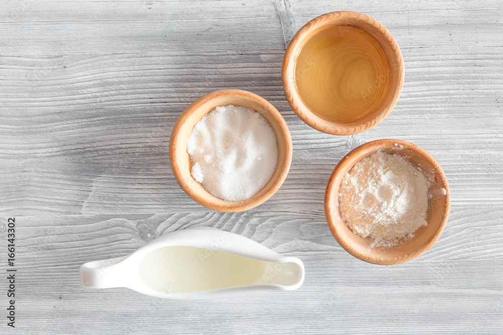 Put the dough. Flour, salt, mik, oil, rolling pin on light wooden table background top view copyspace Put the dough. Flour, salt, mik, oil, rolling pin on light wooden table background top view copyspace