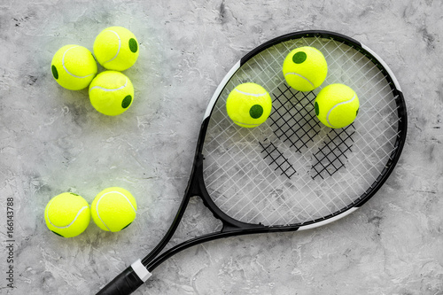 Sport background. Tennis balls and racket on grey background top view © 9dreamstudio