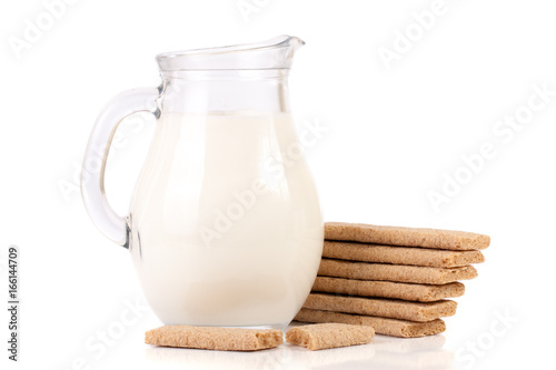 jug of milk with stack of grain crispbreads isolated on white background