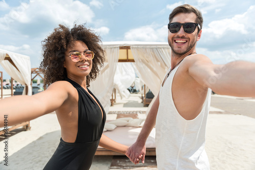 Cheerful affectionate young couple resting together on summer weekend