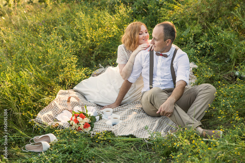 Attractive Couple Enjoying Romantic Sunset Picnic in the Countryside © diter