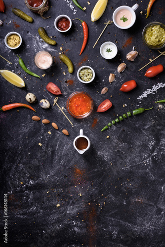 Sauces and dips, ingredients and snack on messy table background. Top view.