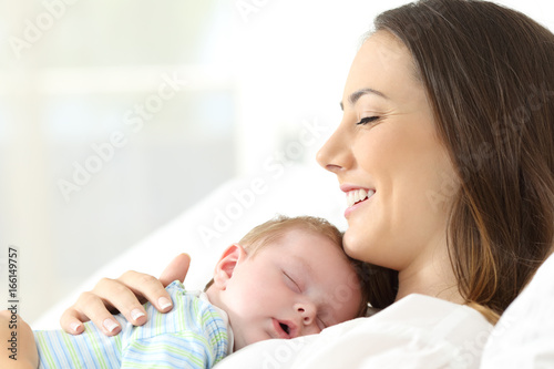 Joyful mother sleeping with her baby