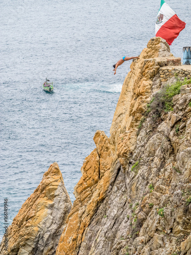 Cliff diver, diving 115 feet into the Pacific Ocean in Acapulco, a major seaport and tourist resort in the state of Guerrero on west coast of Mexico, 