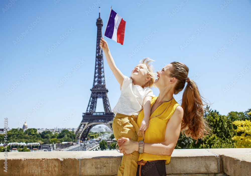 Naklejka premium szczęśliwa matka i dziecko turystów rośnie flaga w Paryżu, Francja