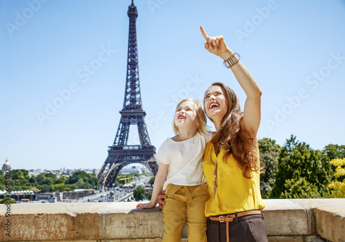 mother and child pointing on something against Eiffel tower