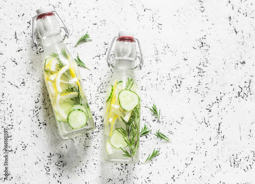 Rosemary, lemon, cucumber refreshing water in vintage bottles on a white background. Healthy refreshing lemonade