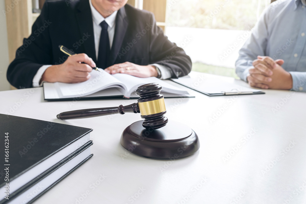 Close up of gavel, Male lawyer or judge Consult with client and working with Law books, report the case on table in modern office, Law and justice concept Close up of gavel, Male lawyer or judge Consult with client and working with Law books, report the case on table in modern office, Law and justice concept