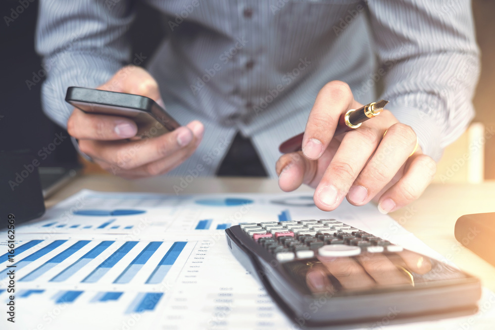 Business man or accountant working Financial investment on calculator with calculate Analyze business and market growth on financial document data graph and smart phone,Accounting,Economic,commercial