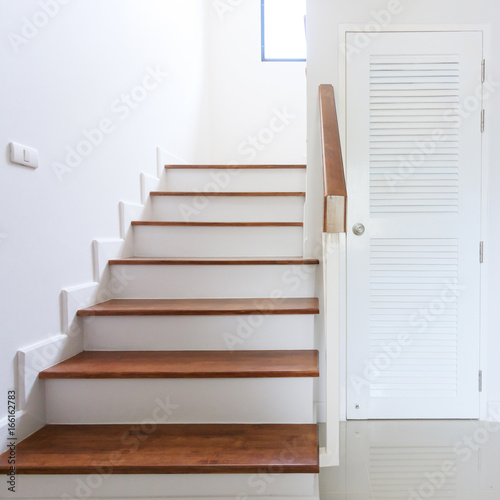 inside contemporary white modern house with wood staircase and pvc door © sutichak