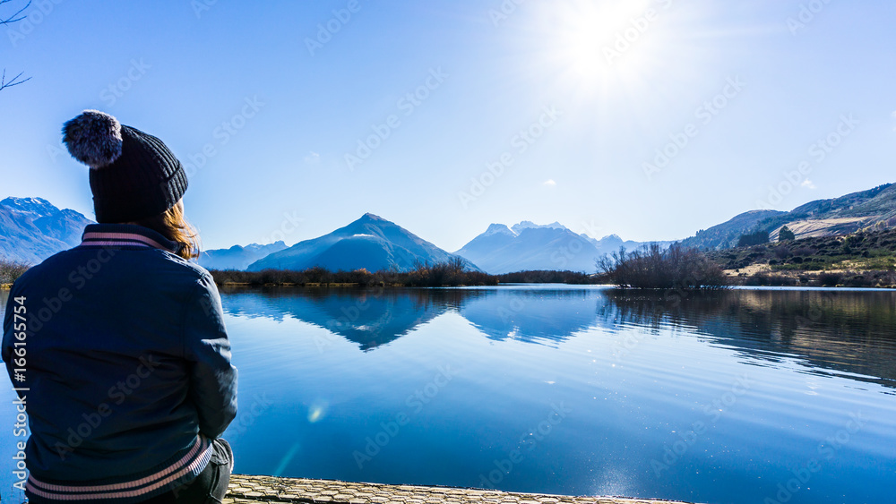 Girl sitting by Lakefront Landscape