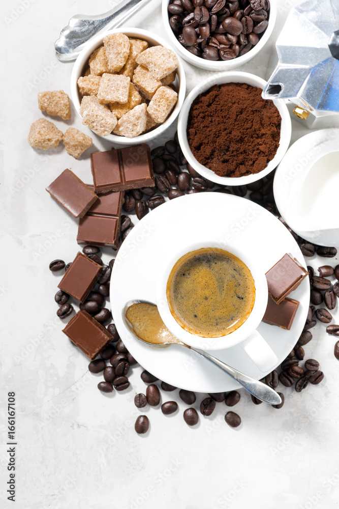 cup of espresso, ingredients and sweets on white background, vertical, top view cup of espresso, ingredients and sweets on white background, vertical, top view