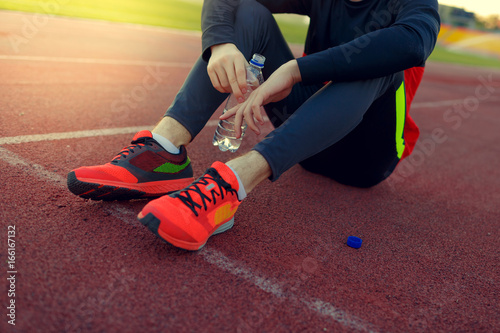 Athlete drinks water at the stadium on a hot sunny day