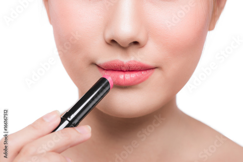 Beautiful young asian woman applying pink lipstick © makistock