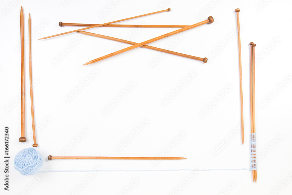 Knitting needles and blue yarn ball frame on white background Knitting needles and blue yarn ball frame on white background