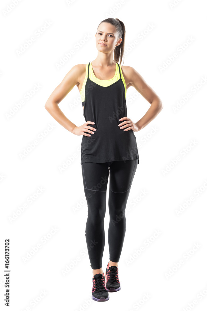 Fototapeta premium Satisfied confident active healthy woman in sports clothing with hands on hips. Full body length portrait isolated on white background.