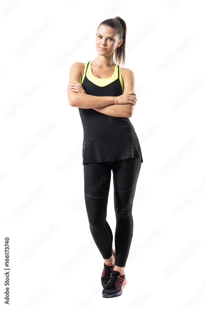 Active young healthy fit sporty woman with crossed arms looking at camera. Full body length portrait isolated on white background. Active young healthy fit sporty woman with crossed arms looking at camera. Full body length portrait isolated on white background.