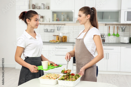 Young woman serving lunch t...