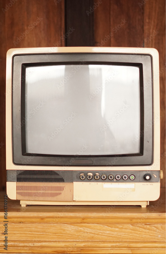Retro old television in vintage wooden wall brown background.