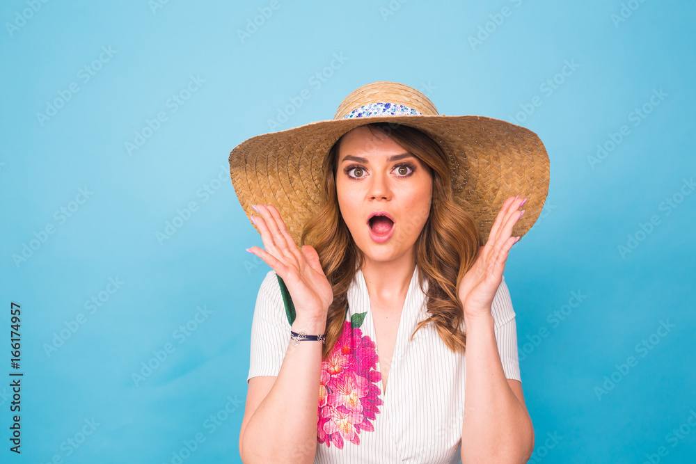 Beautiful excited surprised young woman over blue background with copy space.