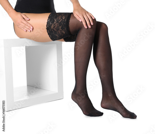 Beautiful young woman in black stockings on white background photo