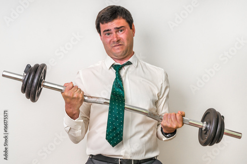 Businessman with barbell is lifting heavy weight