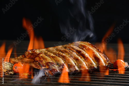  Grilled pork ribs with vegetable on the flaming grill