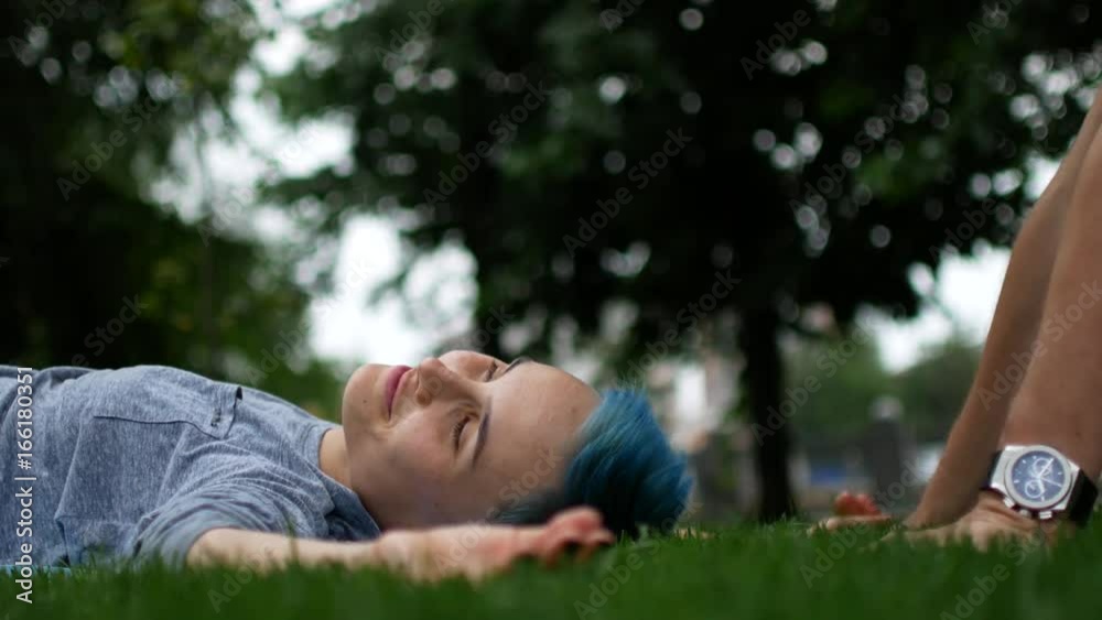 The girl is lying on the grass and the guy is kissing her. A loving couple on the grass. Man and woman are a romantic moment. The girl is lying on the grass and the guy is kissing her. A loving couple on the grass. Man and woman are a romantic moment.