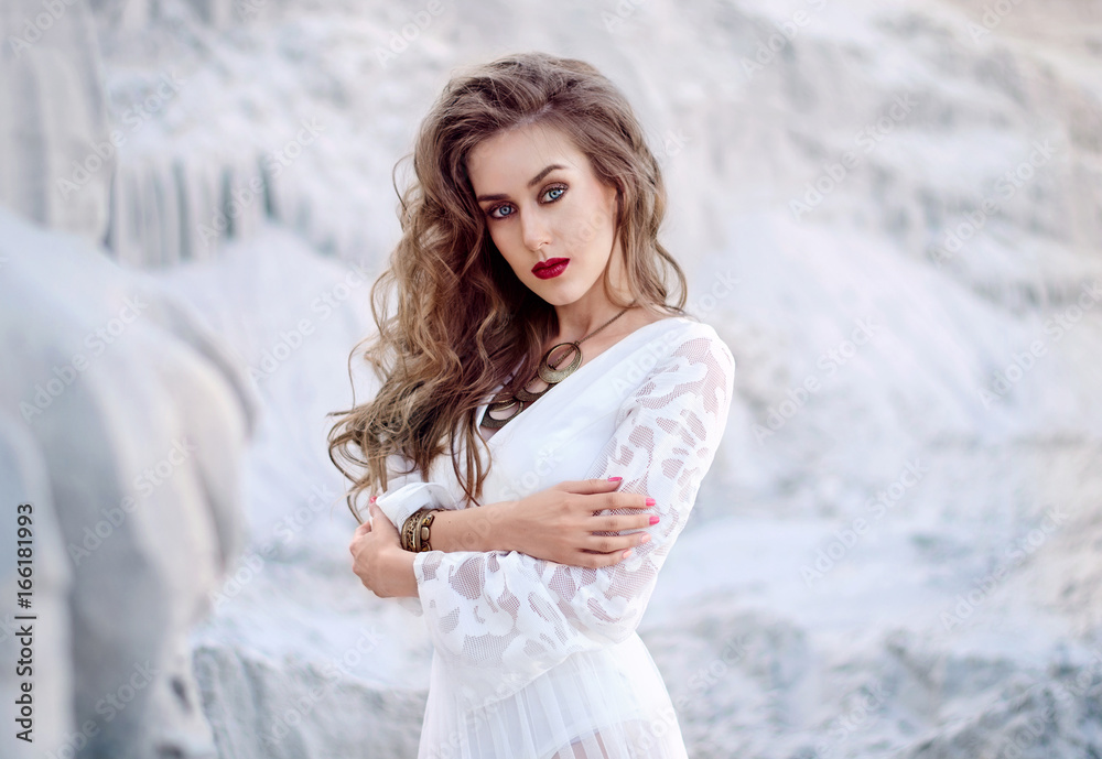 Portraitof attractive young woman in white long dress in the desert. Boho Style Portraitof attractive young woman in white long dress in the desert. Boho Style